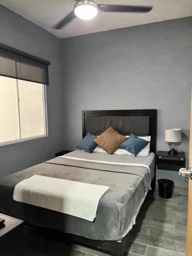 a bedroom with a large bed with blue pillows at Departamento Ecoface Vallarta in Puerto Vallarta