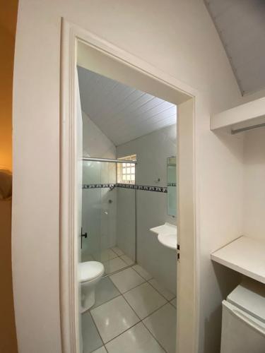 a bathroom with a shower and a sink and a toilet at Pousada Chalés Jardim das Aguas in Olímpia