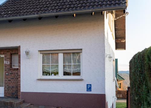 ein weißes Haus mit einem Seitenfenster in der Unterkunft Eifelruhe 3 in Hellenthal