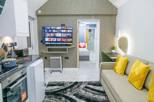 a living room with a couch and a tv at Hot Tub Hideaway, Private Retreat in Walsall