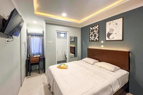 een slaapkamer met een groot bed en een bureau bij Torisan Hotel in Stasiun Tawang