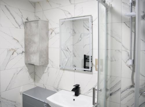 a white bathroom with a sink and a mirror at Hot Tub Hideaway, Private Retreat in Walsall