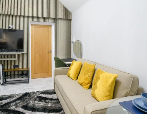 a living room with a couch with yellow pillows at Hot Tub Hideaway, Private Retreat in Walsall