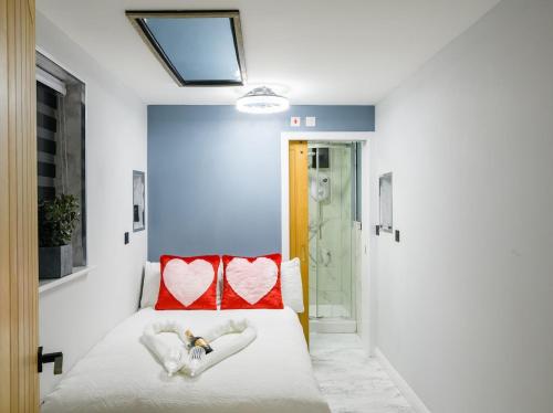 a bedroom with a bed with two red pillows at Hot Tub Hideaway, Private Retreat in Walsall