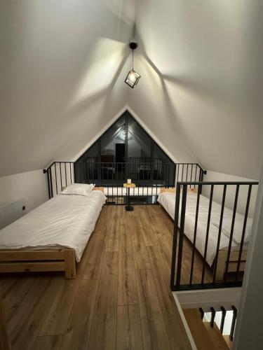 ein Schlafzimmer im Dachgeschoss mit 2 Betten und einer Treppe in der Unterkunft Stodoła Parysa 