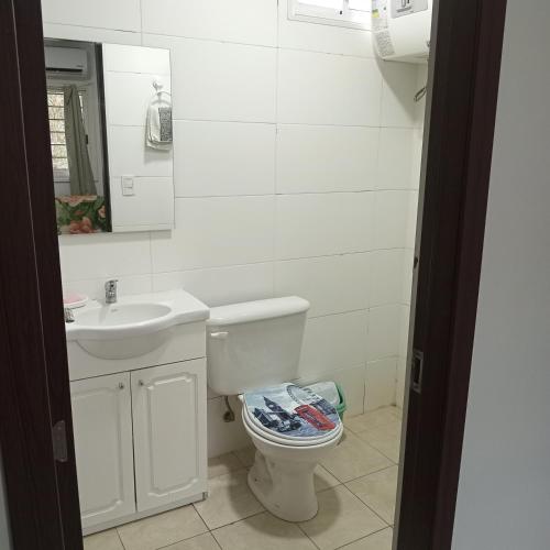 a white bathroom with a toilet and a sink at Casa a 100 nts del mar in Balneario Argentino