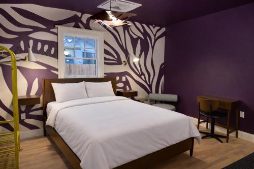 una camera da letto con un letto e una parete viola di Assemble Boise a Boise