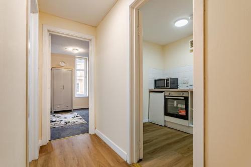 eine Küche mit einer Tür zu einer Küche mit Mikrowelle in der Unterkunft Cosy Retreat Suites in Hamilton