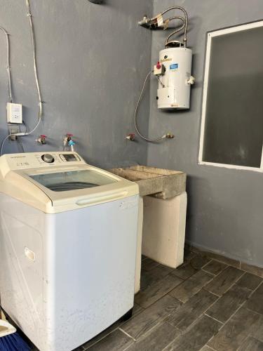 una lavanderia con lavatrice e lavandino di Departamento Ecoface Vallarta a Puerto Vallarta