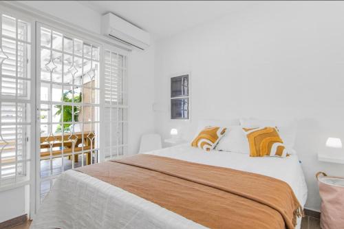 a white bedroom with a large bed and a window at Something Els in Willemstad
