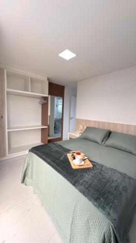 een slaapkamer met een bed met een dienblad erop bij Apto das Rosas - 3 Quartos, Apto todo climatizado, à poucos metros do Parque Termal! in Piratuba