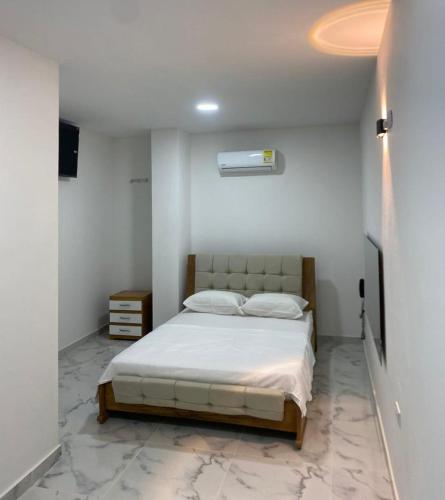 a bedroom with a bed in a white room at Hotel Santa Ana in Baranoa