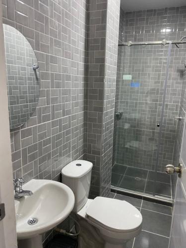 a bathroom with a toilet and a sink and a shower at Hotel Santa Ana in Baranoa