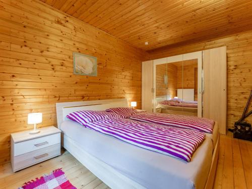 een slaapkamer met een bed in een houten kamer bij Karawankenpanorama in Liebenfels