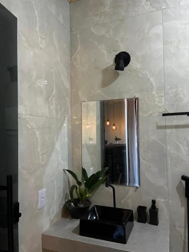 een badkamer met een wastafel en een spiegel bij Chalé vista da vila in Sao Jorge