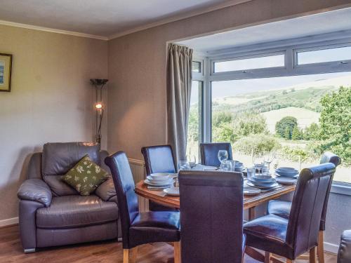 a dining room with a table and chairs and a window at Lilybank Cottage in Doularg