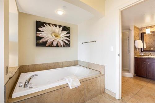 a bathroom with a bath tub with a flower painting on the wall at DeeDee Al Resort in Las Vegas