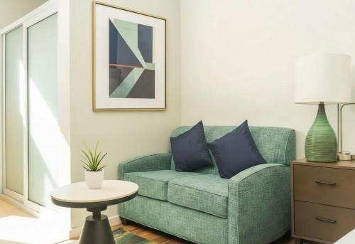 een woonkamer met een groene bank en een tafel bij Soma Dream Hotel Georgetown Guyana in Georgetown