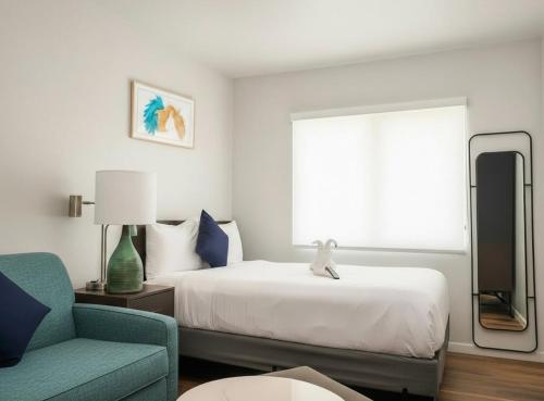 een slaapkamer met een bed, een stoel en een spiegel bij Soma Dream Hotel Georgetown Guyana in Georgetown