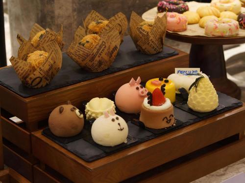 a display of different types of cakes and pastries at Mercure Xi'an Stadium Hotel in Xi'an