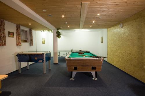 a room with a pool table and two tables at Hotel Alpenpanorama in Söll