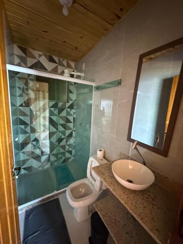 ein Badezimmer mit Waschbecken, Toilette und Spiegel in der Unterkunft Araçatiba Praia Flats in Angra dos Reis