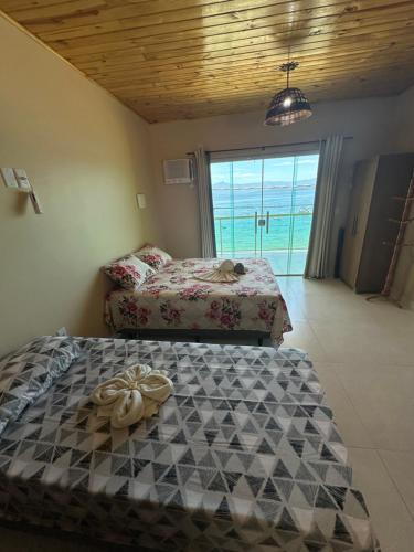 zwei Betten in einem Zimmer mit Meerblick in der Unterkunft Araçatiba Praia Flats in Angra dos Reis
