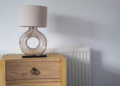 a lamp sitting on top of a wooden nightstand at NECAirport M6 Free Parking Nr Solihull Town in Solihull