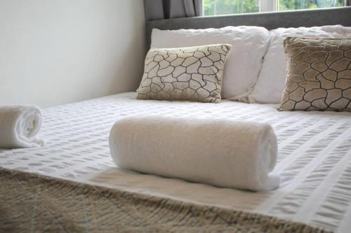 a bed with a white comforter and pillows at NECAirport M6 Free Parking Nr Solihull Town in Solihull