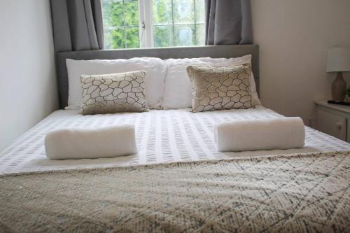 a large bed with white sheets and pillows at NECAirport M6 Free Parking Nr Solihull Town in Solihull
