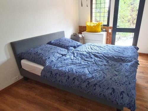 a bed with a blue comforter in a bedroom at Poolside Apartment in Italian Villa in San Lorenzo al Mare