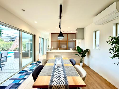 a dining room with a table and a kitchen at Futtsu Pool Villa A&F -富津プールヴィラ A&F- in Futtsu