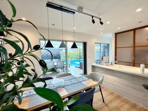 a dining room and kitchen with a table and a plant at Futtsu Pool Villa A&F -富津プールヴィラ A&F- in Futtsu