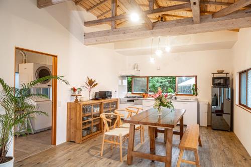 a kitchen and dining room with a table and chairs at Lucia Seaside Villa Amami in Amami