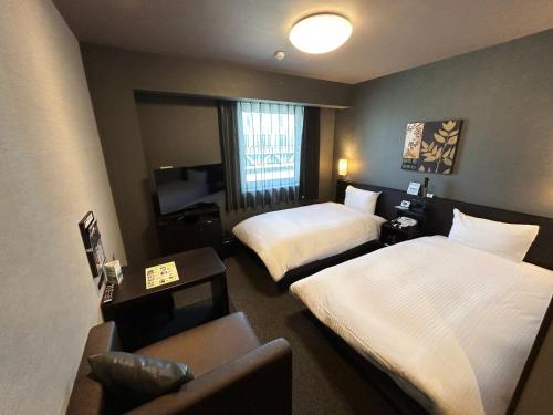 Postel nebo postele na pokoji v ubytování Hotel Route-Inn Katori Sawara Ekimae