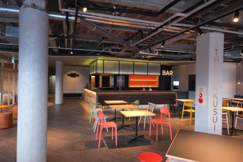 een restaurant met tafels en stoelen en een bar bij The GAKUSUI in Hakuba