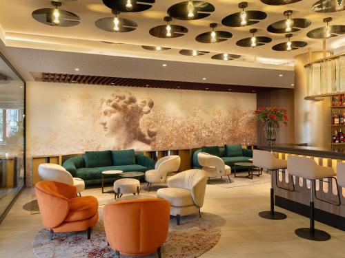 Mercure Sofia City في صوفيا: غرفة انتظار بها أرائك وكراسي ولوحة فنية