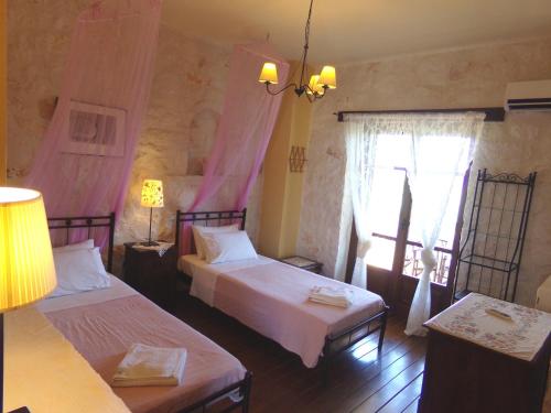 a bedroom with two beds and a window at Alegria Villas Complex in Vasilikos