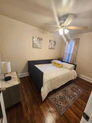 een slaapkamer met een bed en een plafondventilator bij Lansdowne Gem in Lansdowne