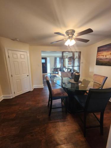 a dining room with a table and chairs and a ceiling fan at Lansdowne Gem in Lansdowne