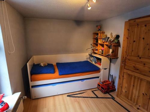 een slaapkamer met een bed met blauwe en oranje lakens bij Farmhouse for arrival in Lütjenwestedt