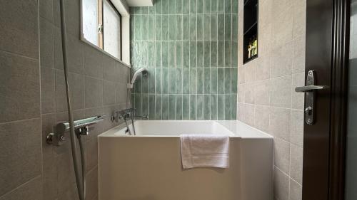 un bagno con vasca e finestra di 涼亭 川 Ryoutei Kawa a Hakuba