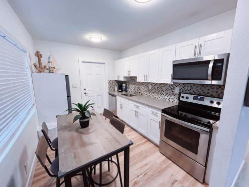 a kitchen with a table and a stove and microwave at Beach Getaway One Block from the Beach in Pompano Beach