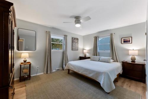 una camera con un letto bianco e due finestre di 204 Glencreek Road a Town Bank