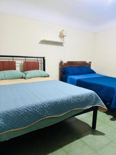 een slaapkamer met 2 bedden en blauwe dekbedden bij Terraza 419 in Tarija