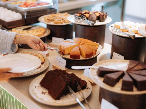 Iemand grijpt naar een stuk chocoladetaart. bij Mövenpick Hotel Bari in Bari