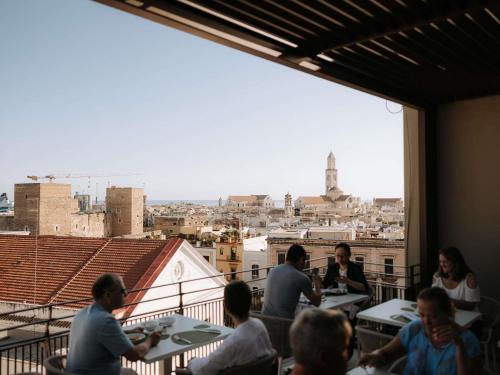 een groep mensen die aan een tafel op een balkon zitten bij Mövenpick Hotel Bari in Bari