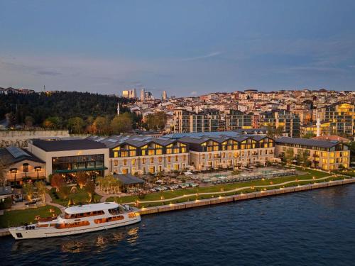 een boot is aangemeerd voor een groot gebouw bij Aliée Istanbul - A Paris Society Collection Hotel in Istanbul