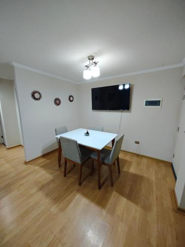 een eetkamer met een tafel en stoelen en een flatscreen-tv bij Cómodo alojamiento 3D 1B excelente ubicacion in Temuco