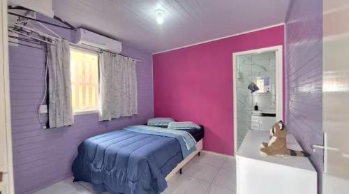 a purple bedroom with a bed and a tub at Casa com jacuzzi in Florianópolis